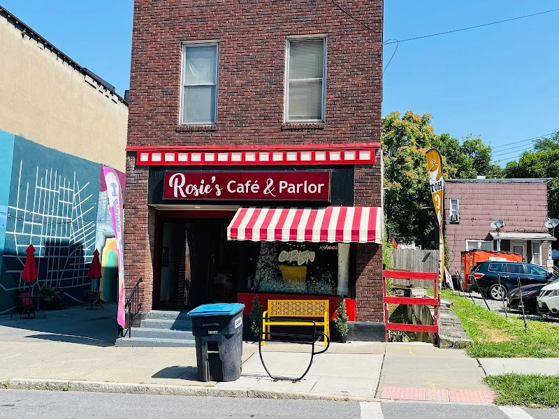 Rosie's Cafe and Parlor storefront with red striped awnings and yellow bench
