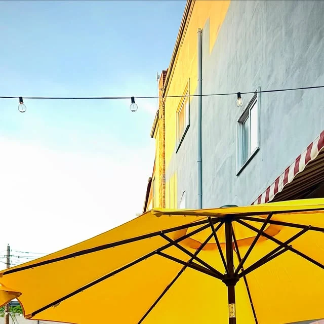 Yellow patio umbrella and string lights outside Rosie's